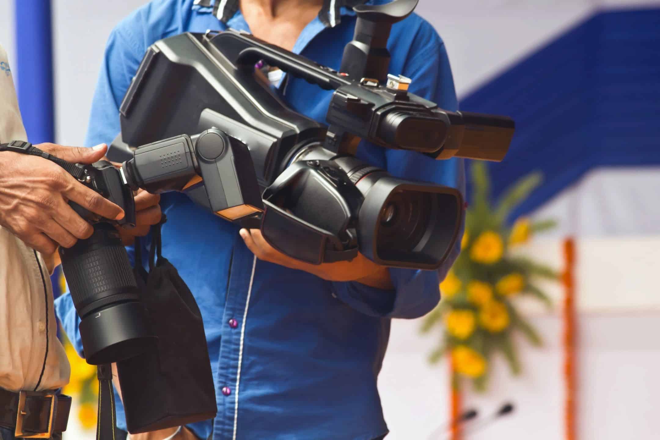 Photography camera held by a woman in a blue jacket