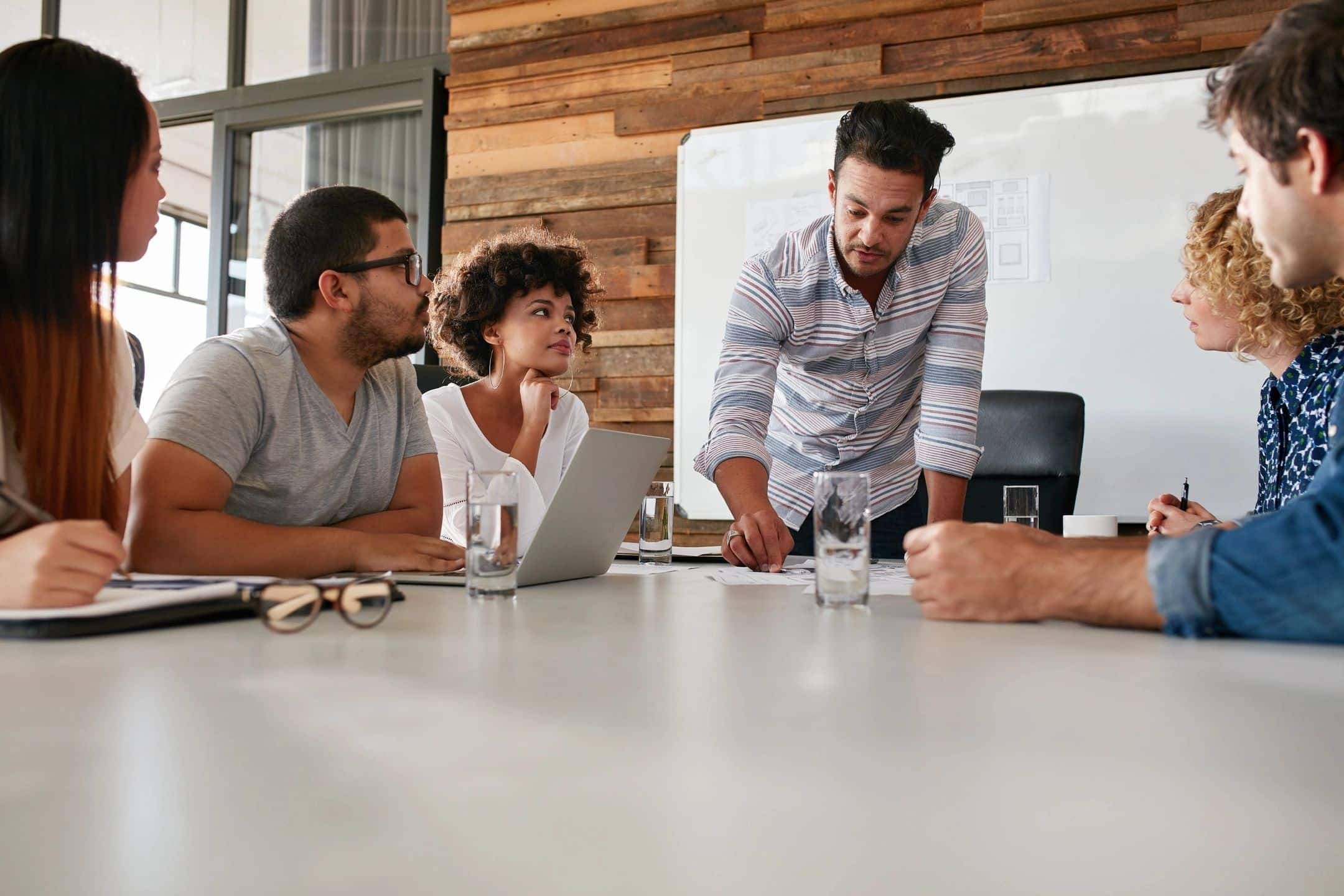 A group of people in business-casual attire gathered around a conference table.