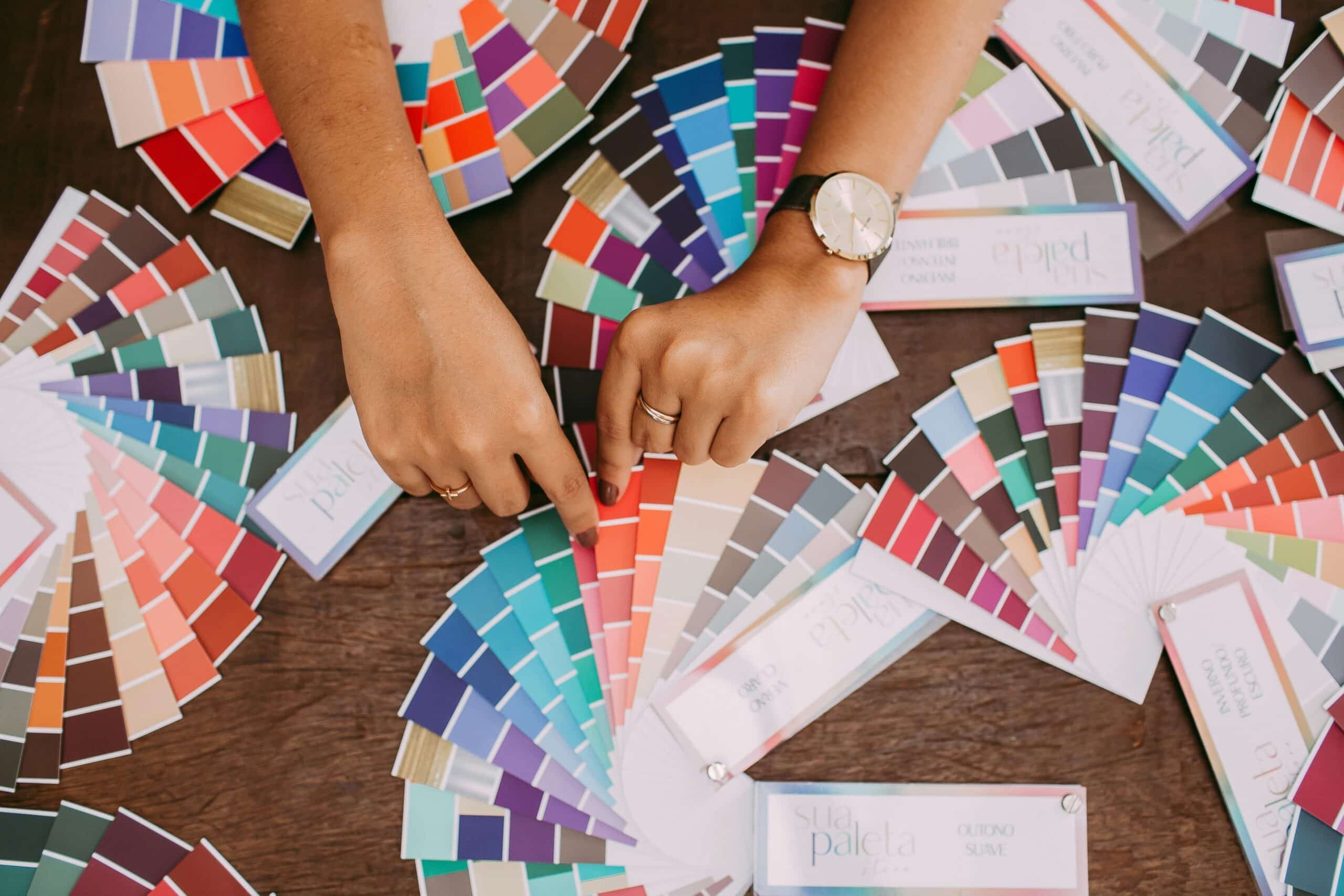 Color swatch samples and hands on a wood table