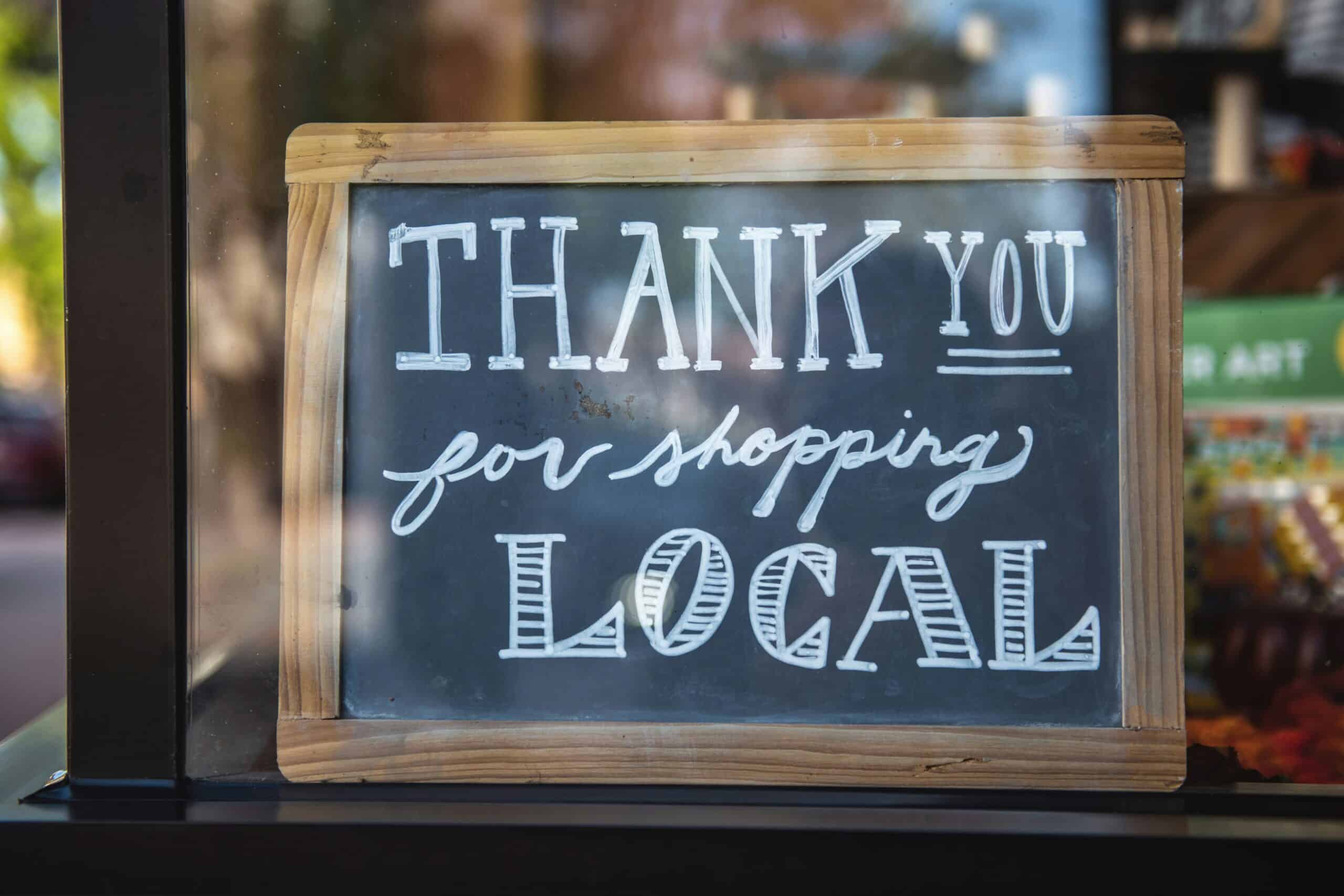 Shallow-scale photo of a small business sign that says "Thank you for shopping local".